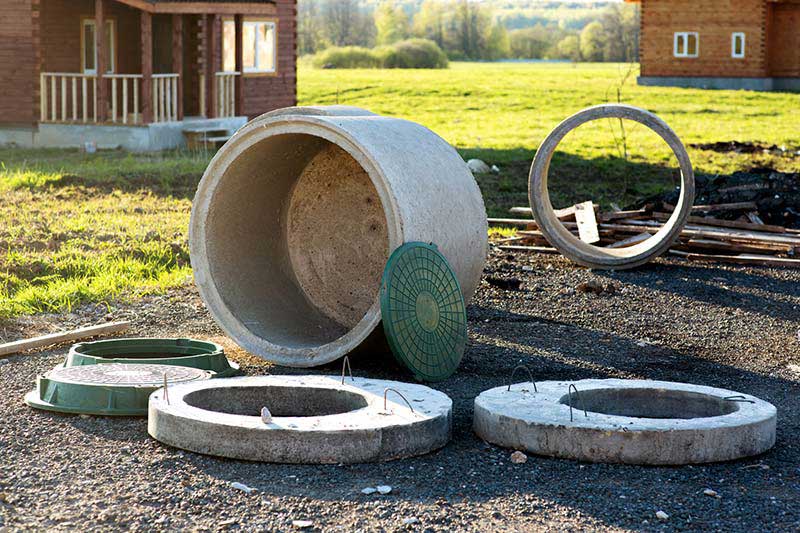 Construction of the sewage septic system with wood cabins in the background